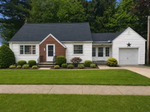 Single-story house exterior home remodel featuring a dark asphalt shingle roof, white horizontal siding, brick entry porch, attached single-car garage and manicured front landscaping